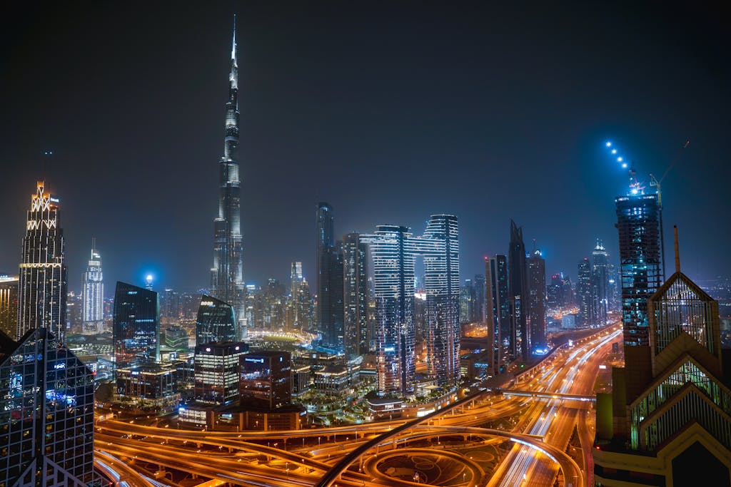 Beautiful night view of Dubai city skyline with Burj Khalifa towering over illuminated roads and skyscrapers.