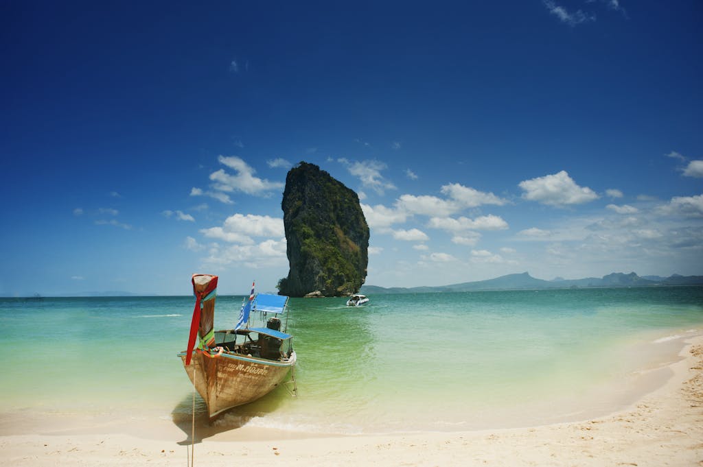 Capture the serene beauty of a Thailand beach with turquoise waters and iconic rock formations.